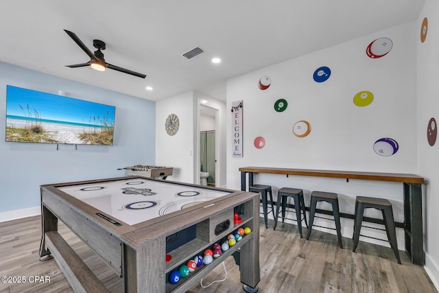 recreation room with visible vents, ceiling fan, baseboards, and wood finished floors