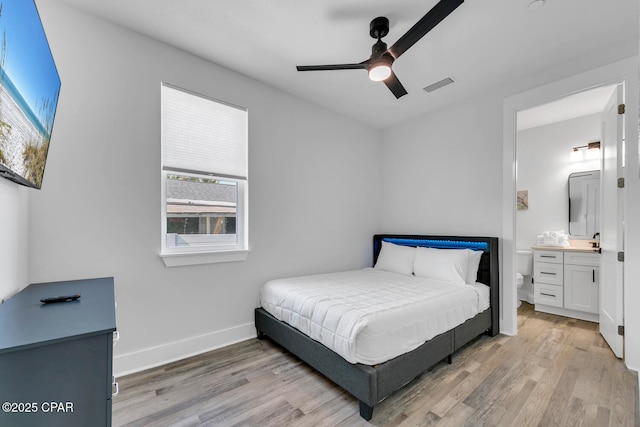 bedroom featuring visible vents, light wood-style flooring, connected bathroom, and baseboards