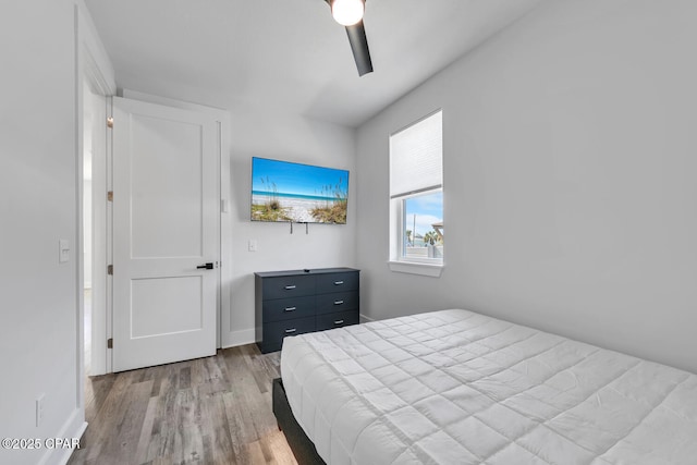 bedroom with ceiling fan, baseboards, and wood finished floors
