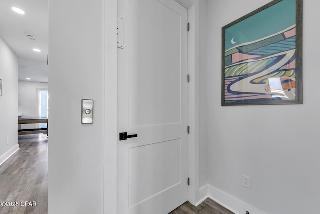corridor featuring recessed lighting, baseboards, and wood finished floors