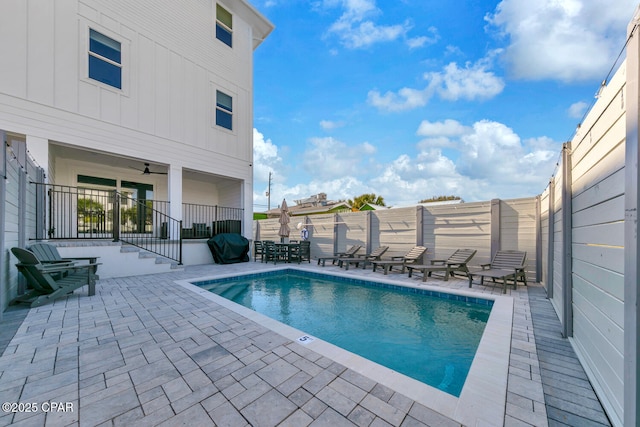 view of swimming pool with a patio area, a fenced in pool, a ceiling fan, and a fenced backyard