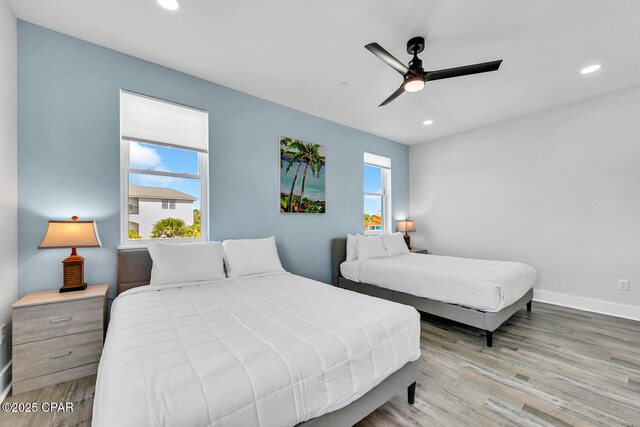 bedroom featuring recessed lighting, multiple windows, and wood finished floors