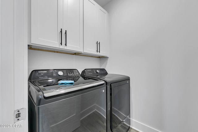 laundry room featuring baseboards, cabinet space, and washing machine and dryer