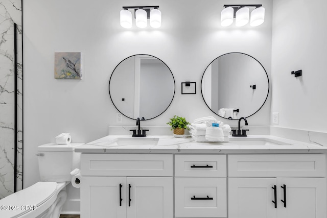 full bathroom with double vanity, toilet, and a sink