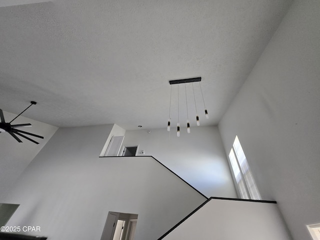 interior space with a textured ceiling and ceiling fan