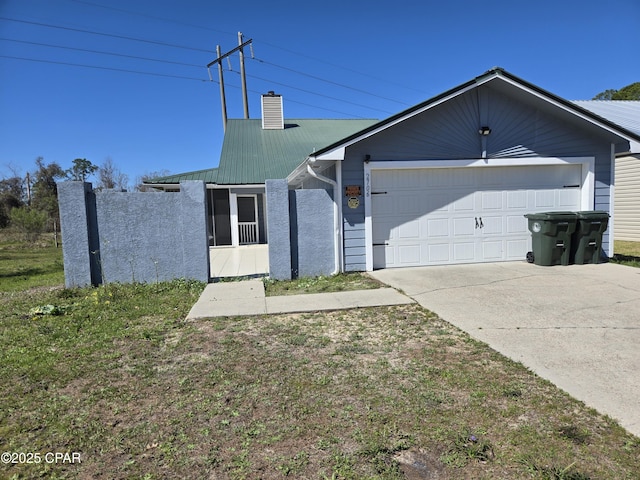 single story home featuring a chimney, driveway, a garage, and metal roof