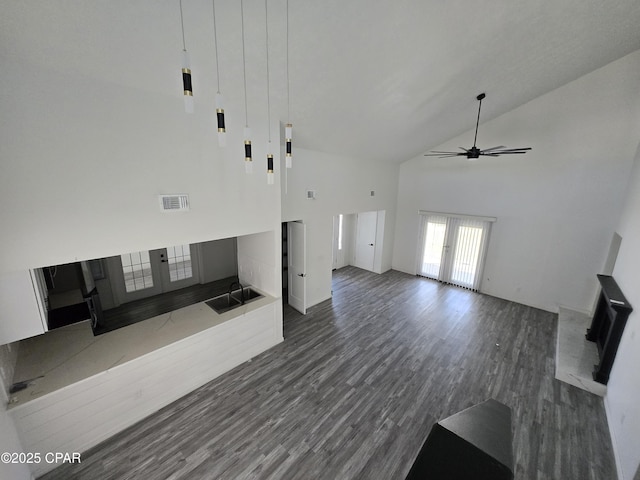 unfurnished living room featuring a ceiling fan, dark wood-style floors, visible vents, high vaulted ceiling, and french doors