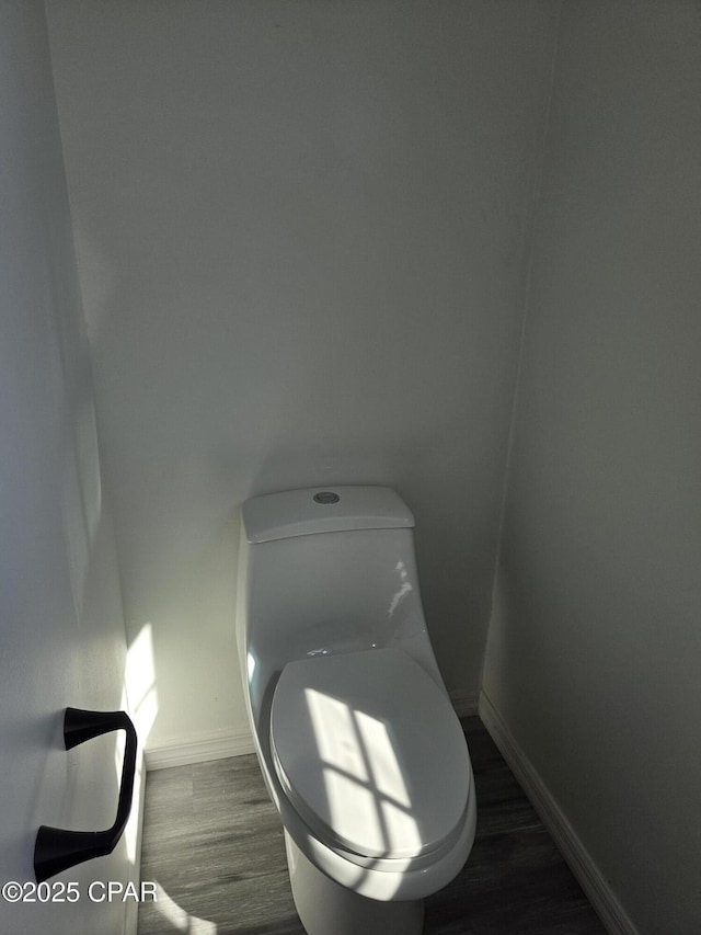 bathroom featuring baseboards, toilet, and wood finished floors