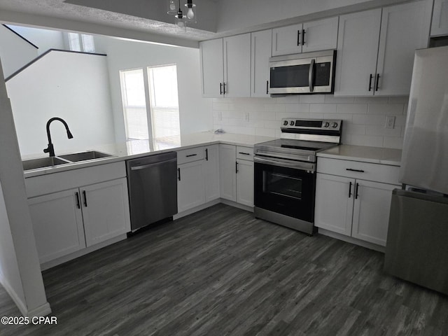 kitchen featuring tasteful backsplash, appliances with stainless steel finishes, dark wood-style flooring, and a sink