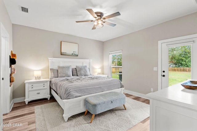 bedroom featuring visible vents, baseboards, light wood-style floors, and access to outside