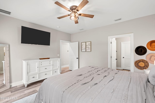 bedroom featuring visible vents, baseboards, light wood-style floors, and a ceiling fan