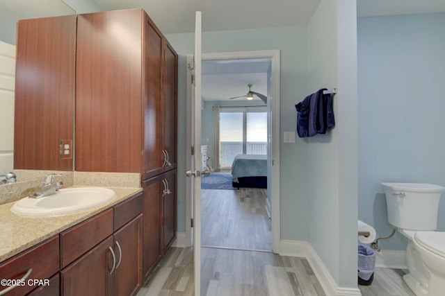 9860 S Thomas Dr Unit 1426, Panama City Beach, FL 32408 - ensuite bathroom featuring toilet, wood finished floors, vanity, baseboards, and a ceiling fan