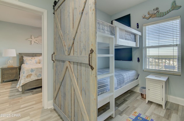 9860 S Thomas Dr Unit 1426, Panama City Beach, FL 32408 - bedroom with a barn door, wood finished floors, and baseboards