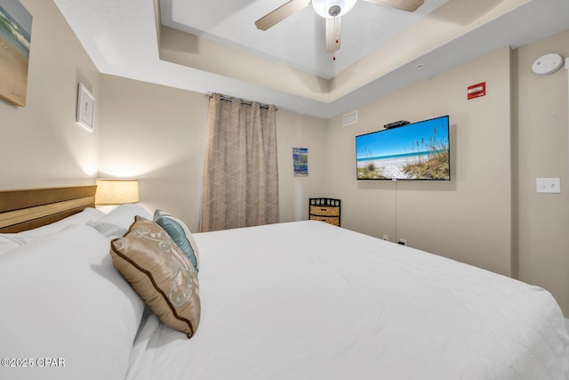 bedroom featuring a tray ceiling, a ceiling fan, and visible vents