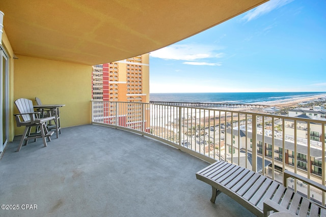 balcony featuring a view of the beach and a water view