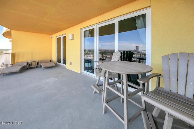 view of patio with outdoor dining area and a balcony