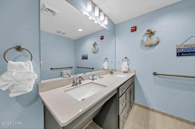 bathroom with double vanity, visible vents, and a sink