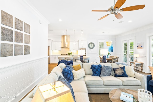 living room with light wood finished floors, visible vents, crown molding, ceiling fan, and recessed lighting