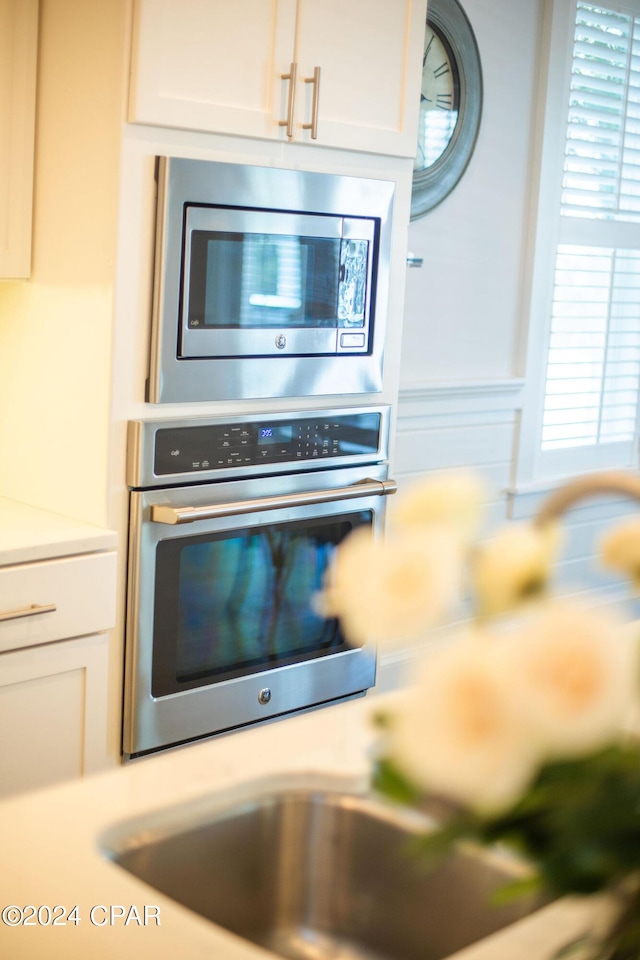 interior details with white cabinetry, light countertops, and appliances with stainless steel finishes