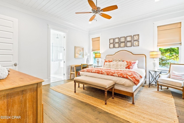 bedroom with hardwood / wood-style floors, multiple windows, and ornamental molding