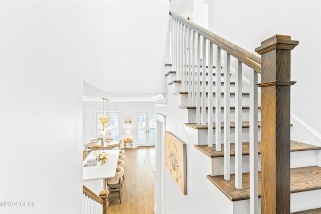 stairs with a high ceiling and wood finished floors