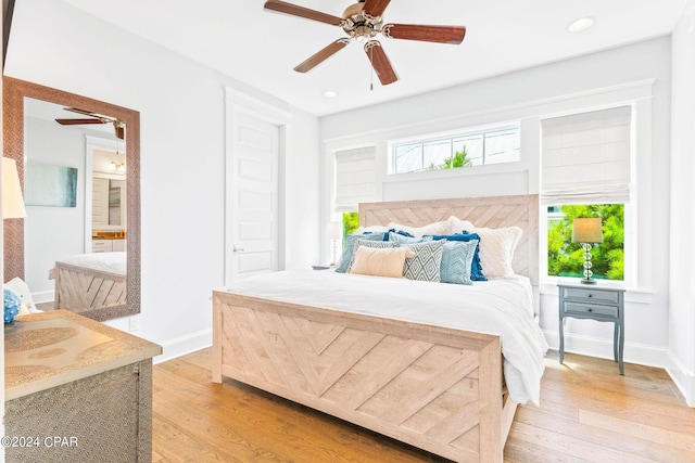 bedroom featuring light wood finished floors, multiple windows, and baseboards