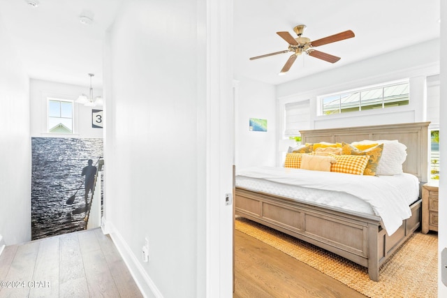 bedroom with baseboards, light wood-type flooring, and ceiling fan