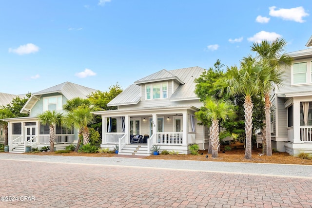 view of front of property with a porch, metal roof, and a sunroom