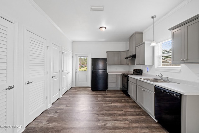 kitchen featuring visible vents, black appliances, gray cabinets, a sink, and crown molding