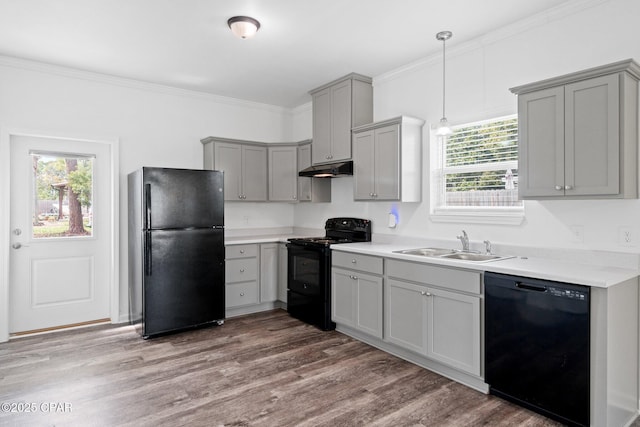 kitchen featuring gray cabinetry, crown molding, under cabinet range hood, black appliances, and a sink