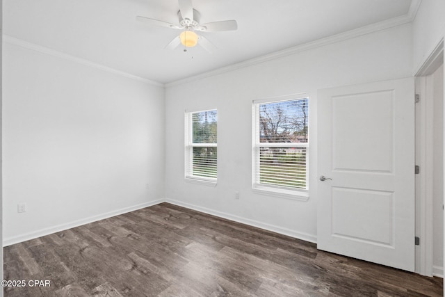 spare room with dark wood finished floors, baseboards, and ornamental molding