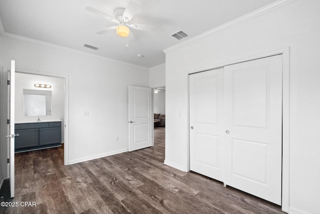 unfurnished bedroom with a closet, visible vents, baseboards, and dark wood-style flooring