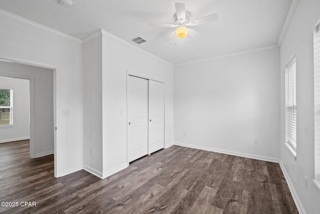 unfurnished bedroom featuring visible vents, dark wood-type flooring, a closet, and ornamental molding