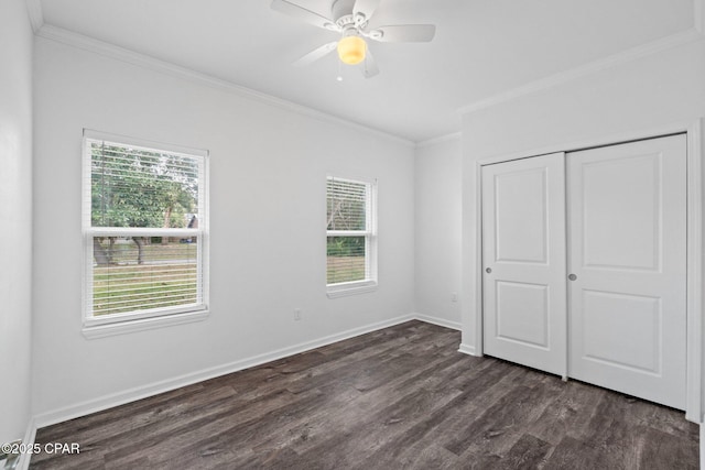 unfurnished bedroom featuring multiple windows, dark wood finished floors, and crown molding