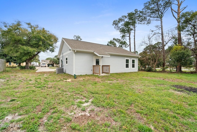 back of property with cooling unit and a yard