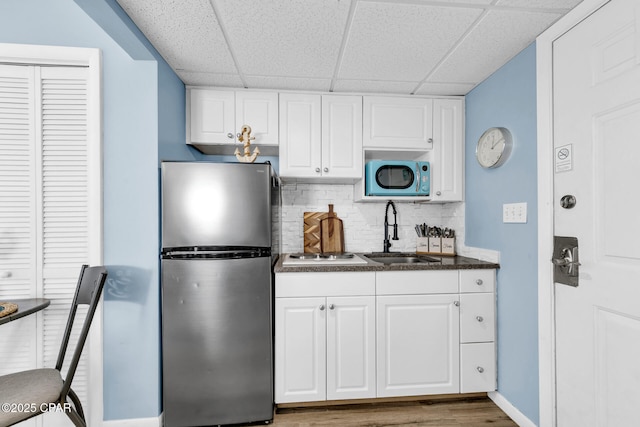 10509 Front Beach Rd Unit 1300E, Panama City Beach, FL 32407 - kitchen featuring decorative backsplash, freestanding refrigerator, dark countertops, a sink, and a paneled ceiling