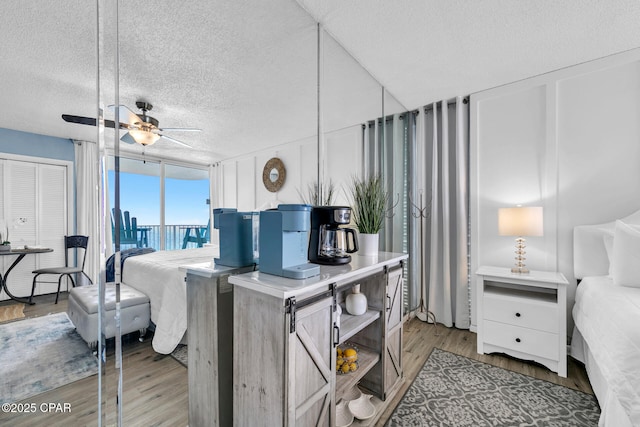 10509 Front Beach Rd Unit 1300E, Panama City Beach, FL 32407 - bedroom with light wood-type flooring, a textured ceiling, and floor to ceiling windows