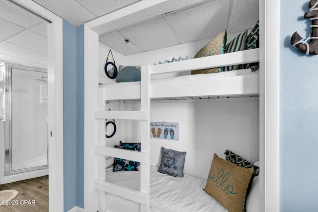 bedroom featuring wood finished floors and a drop ceiling