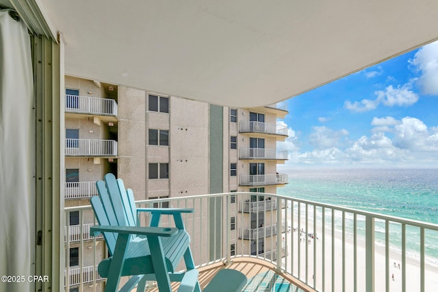 balcony with a water view and a beach view