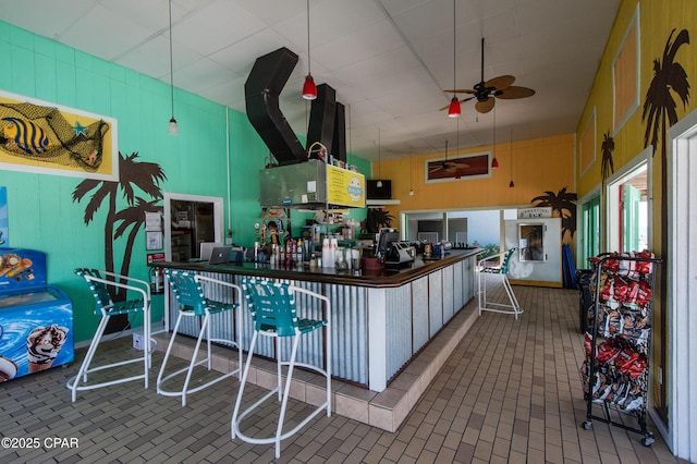 kitchen featuring a ceiling fan, brick floor, and a towering ceiling