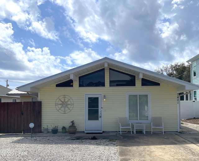 rear view of house with a patio area and fence