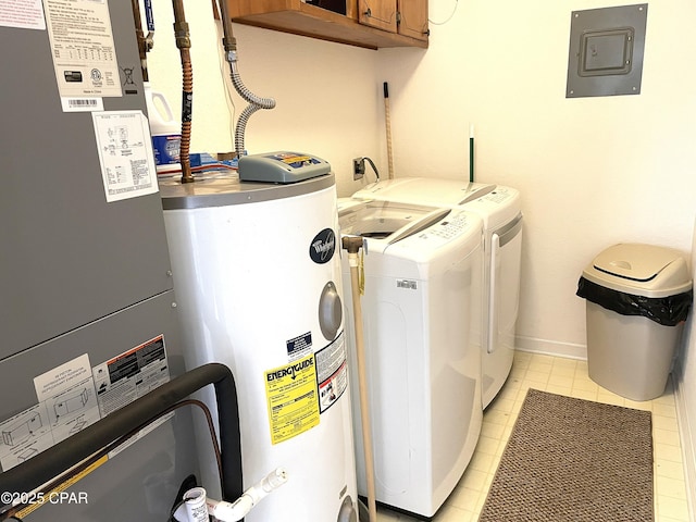 laundry room featuring baseboards, washing machine and dryer, electric panel, water heater, and cabinet space