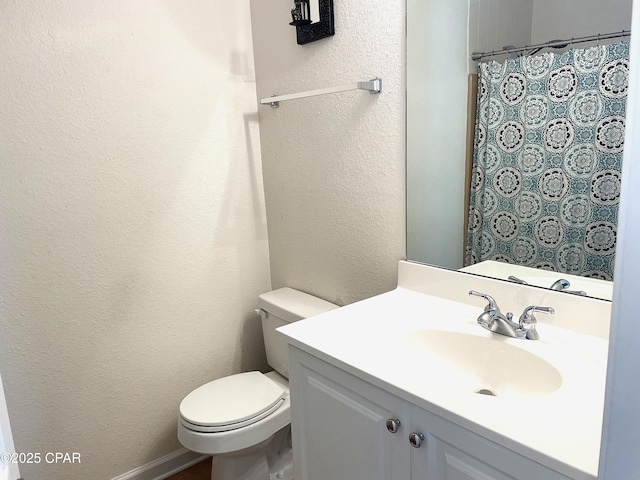 full bath featuring vanity, a shower with curtain, toilet, and a textured wall