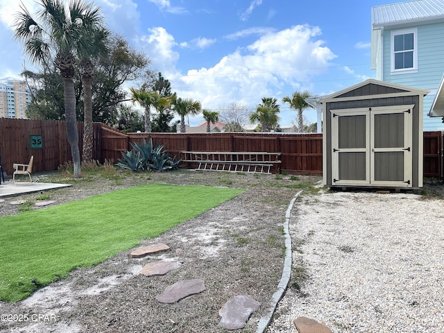 view of yard with an outbuilding, a storage shed, and a fenced backyard