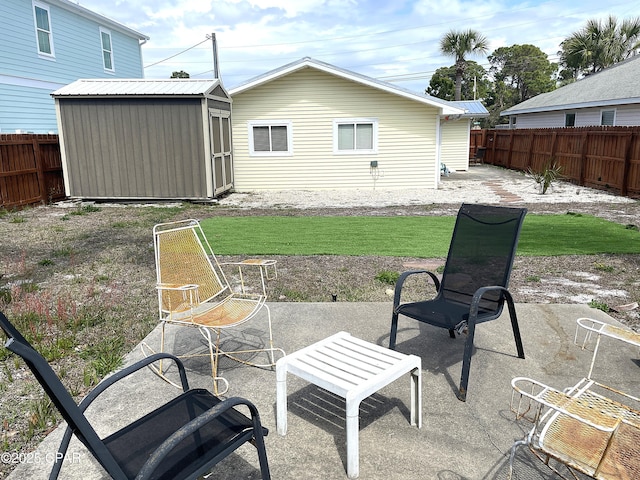 back of property featuring a patio, a fenced backyard, a shed, an outdoor structure, and metal roof