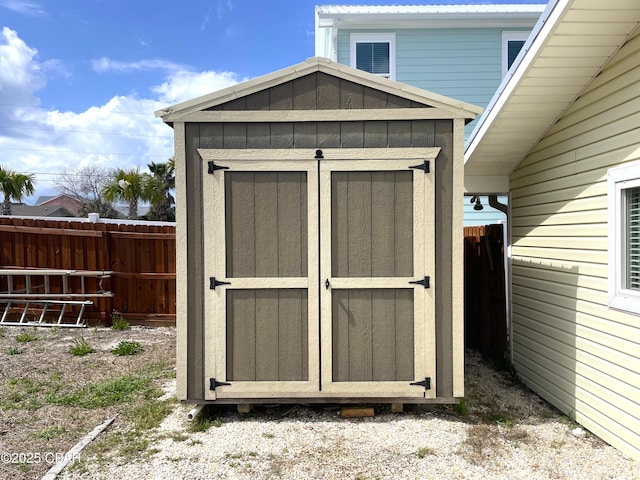 view of shed featuring fence