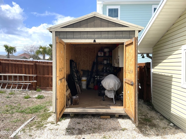 view of shed featuring fence