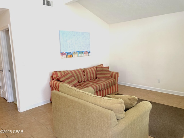 living area featuring light tile patterned floors, visible vents, and baseboards