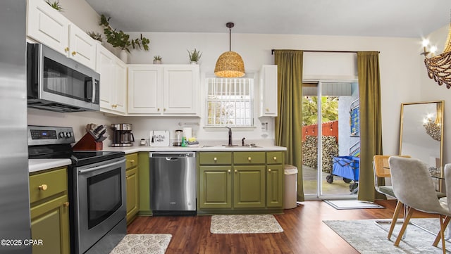 kitchen with green cabinetry, appliances with stainless steel finishes, white cabinets, and a sink