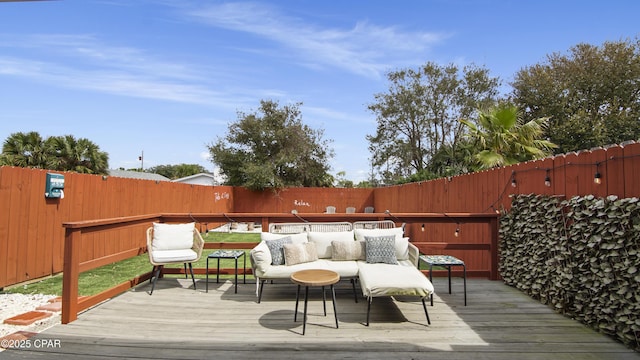 wooden terrace with an outdoor living space and fence